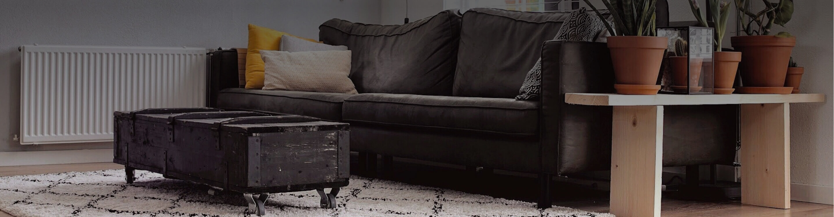 black leather couch with cream area rug